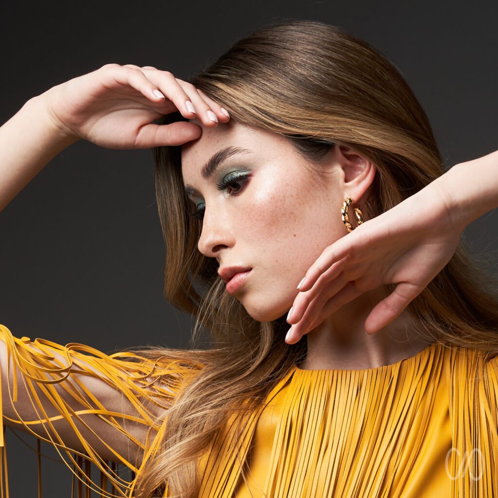 5 Tips para Fotos estilo Beauty foto de joven rubia con vestido amarillo jugando con sus manos frente a su cara de forma delicada