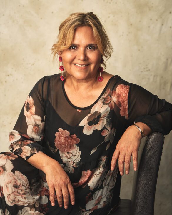 Mujer sentada con vestido de flores y el cabello recogido