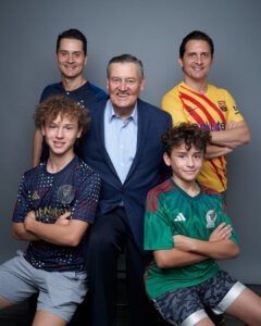 Fotografía Familiar de un abuelo con sus dos hijos y sus dos nietos vistiendo playeras de equipos de soccer