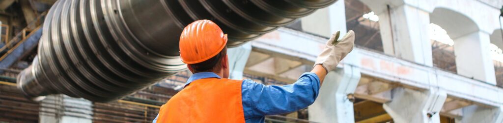 Trabajador en fabrica con chaleco y casco naranja