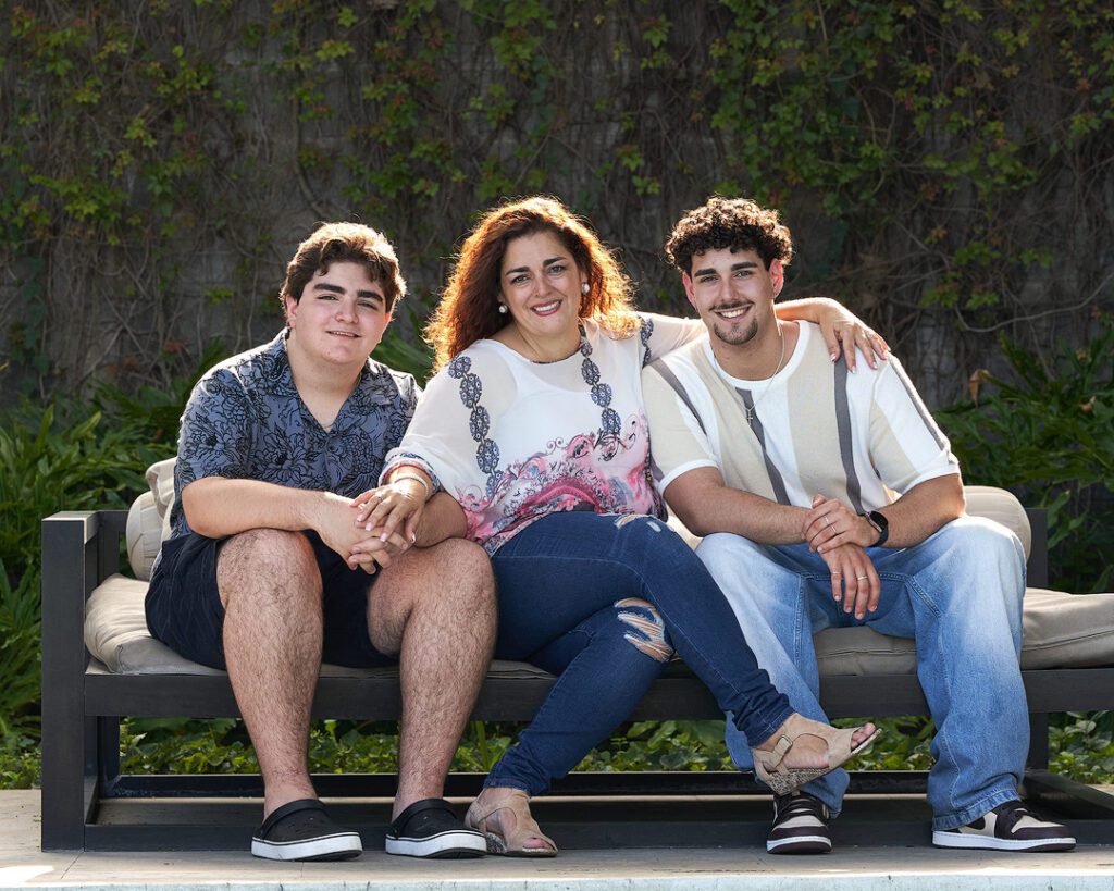 Madre y sus hijos en los 20 años sentados con el sol a sus espaldas