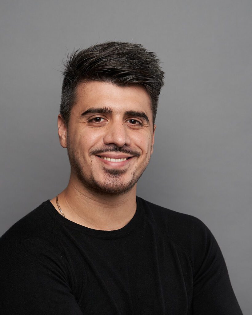 hombre con playera negra, sonriendo