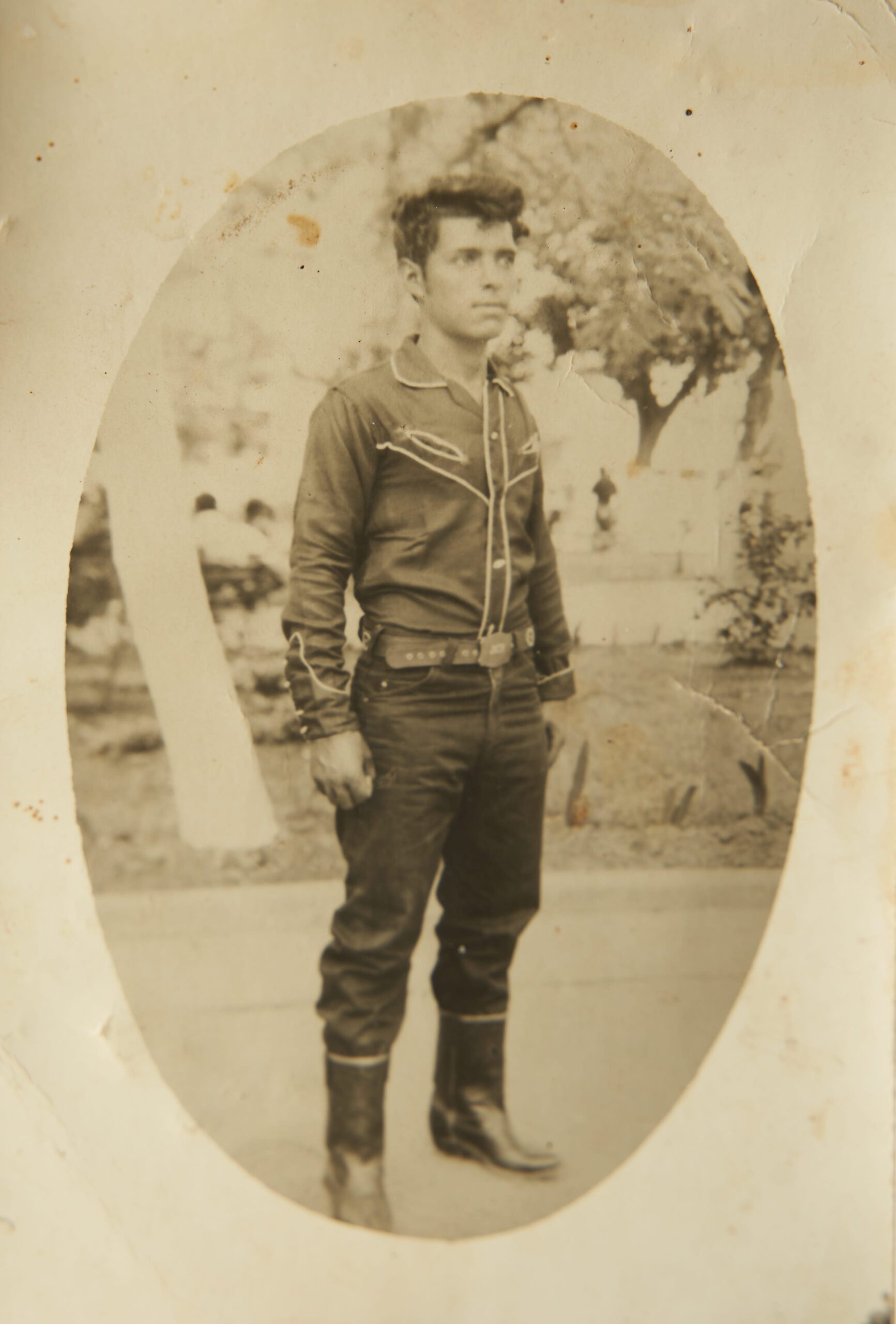 Foto antigua de hombre joven en parque con camisa estilo vaquero