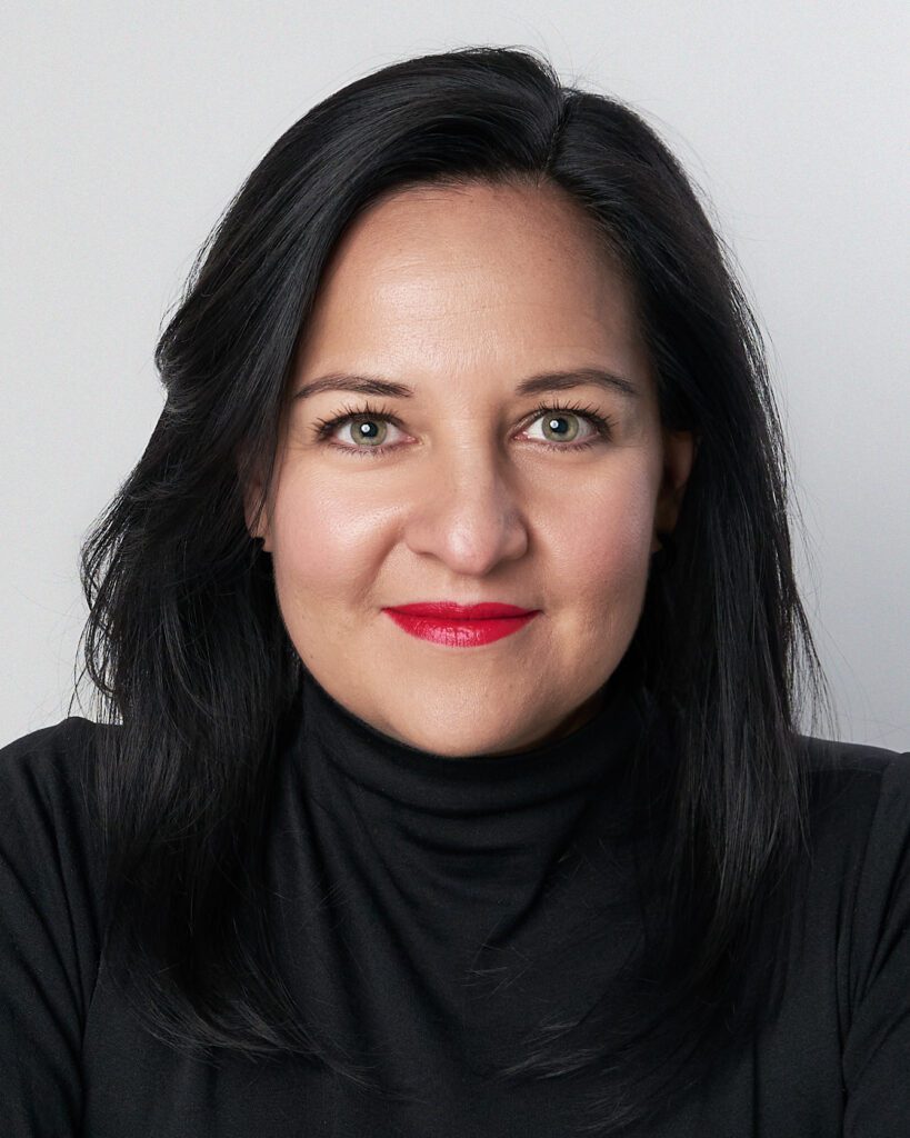 Foto frontal de mujer con blusa negra y ojos verdes