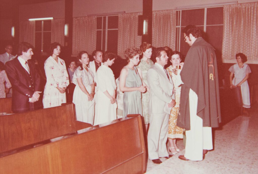 Foto antigua en una iglesia, con personas en fila para comulgar