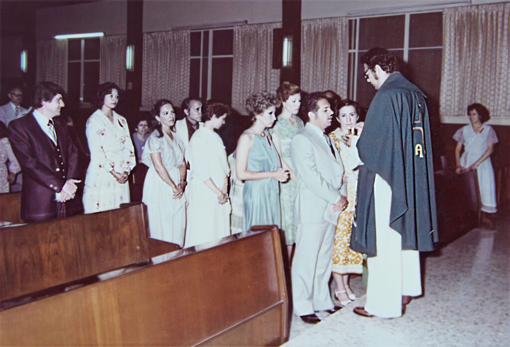 Foto antigua restaurada en una iglesia, con personas en fila para comulgar