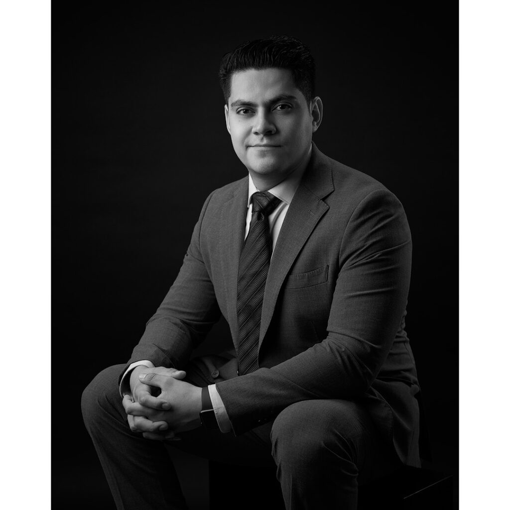 Hombre joven, sentado con traje y corbata en foto en blanco y negro