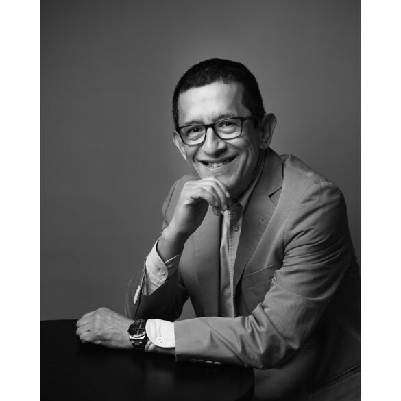 Escritor mostrando sonrisa apoyado sobre mesa