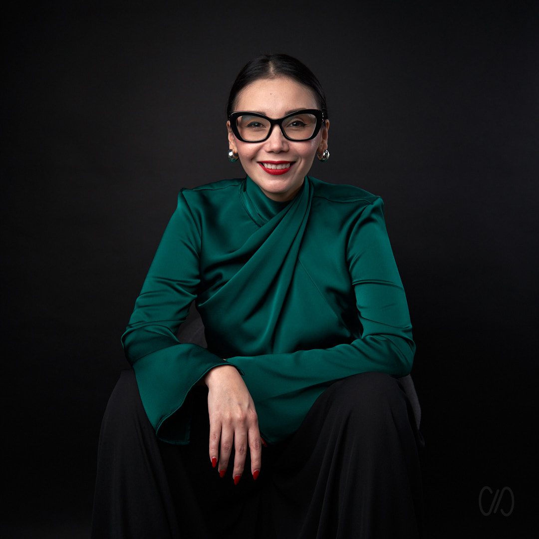 Mujer ejecutiva con lentes negros y blusa verde esmeralda capturada por el Mejor fotógrafo de perfil profesional en Monterrey