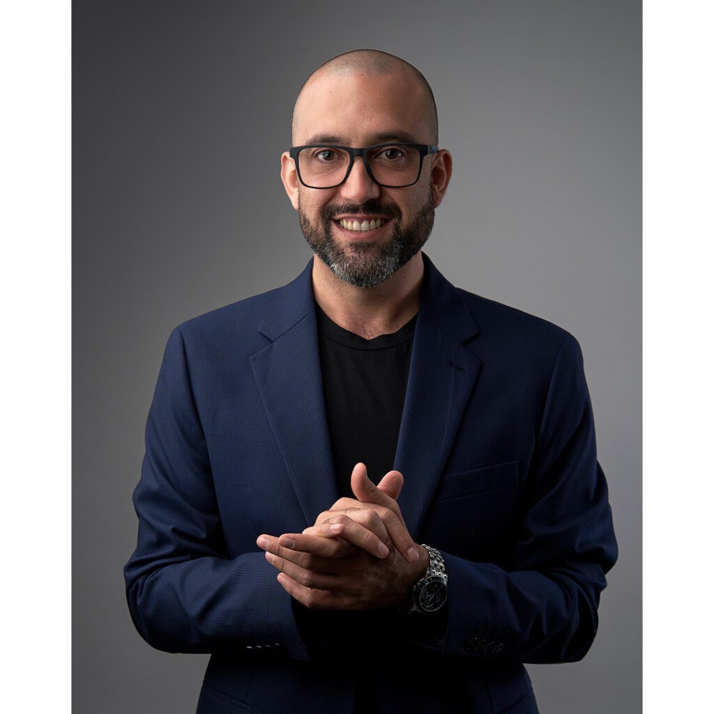 Precio Paquetes Fotos Perfil Profesional en Monterrey de ejecutivo con blazer azul sobre playera negra con manos juntas al fente del pecho