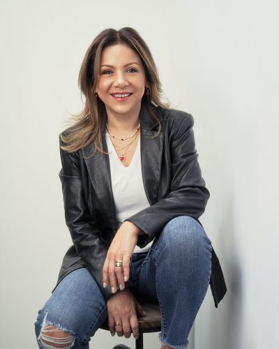 Retrato Femenino mar. 02 2022 AV 2 Retrato de mujer con chamarra de piel negra sentada en banco alto
